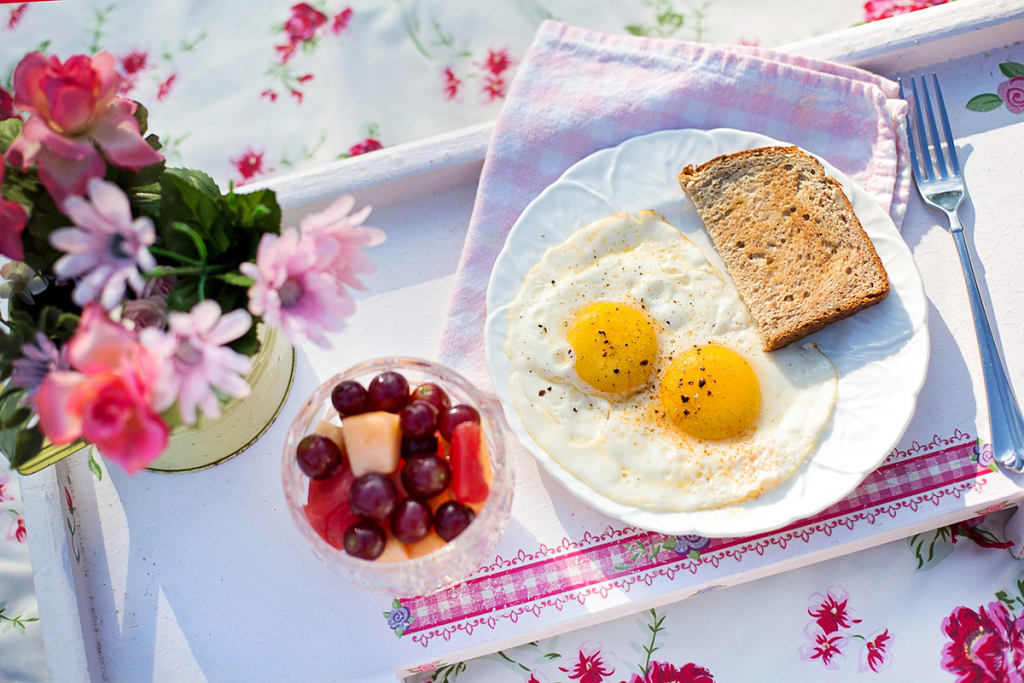 Eggs, toast, and fruit on a tray.