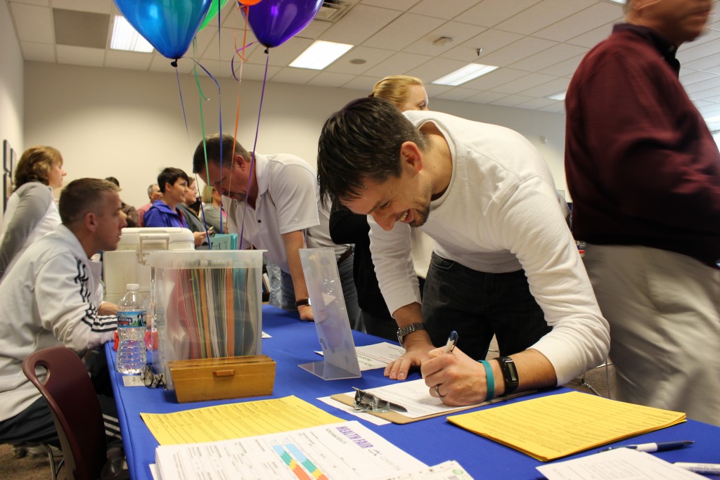 Man signing in at employee wellness health fair