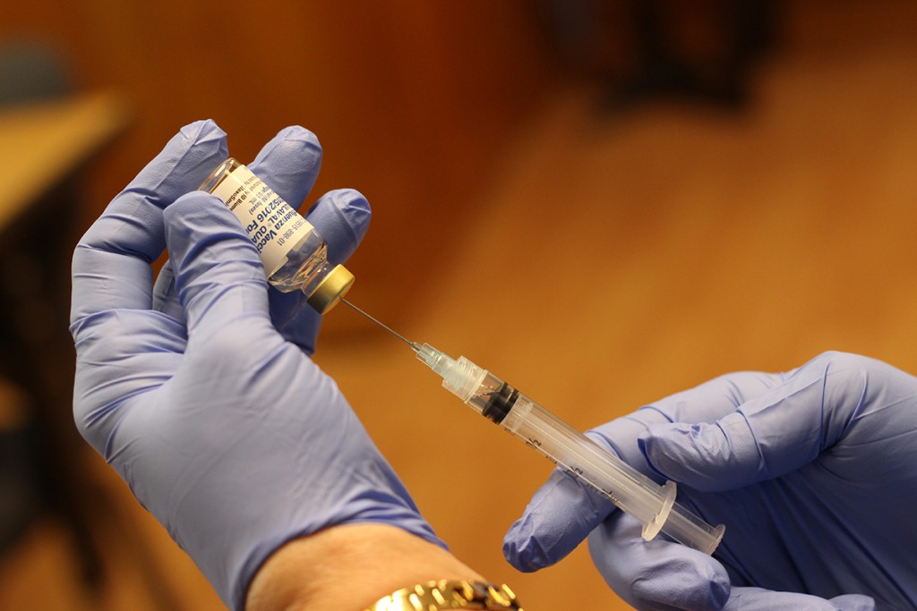 Flu vaccine being drawn from bottle