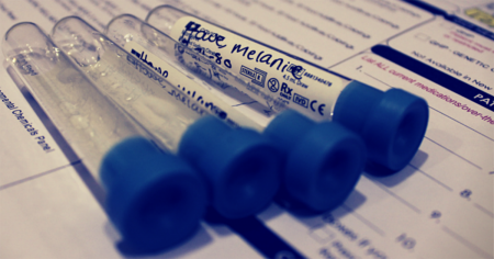 Empty blood test tubes on paperwork.