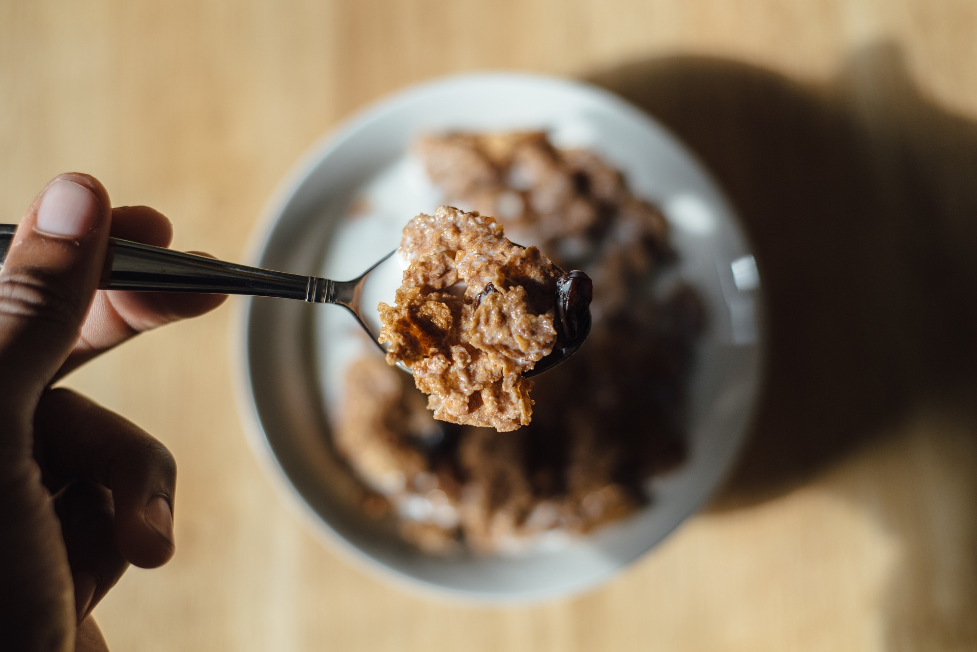 Spoonful of cereal above bowl