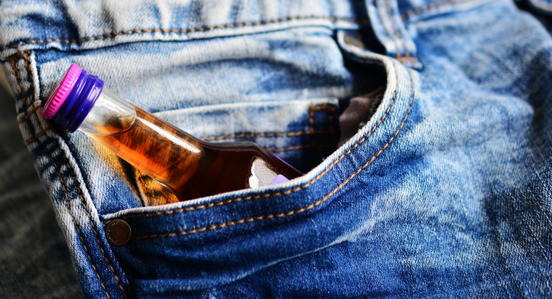 Miniature alcohol bottle in pocket of jeans