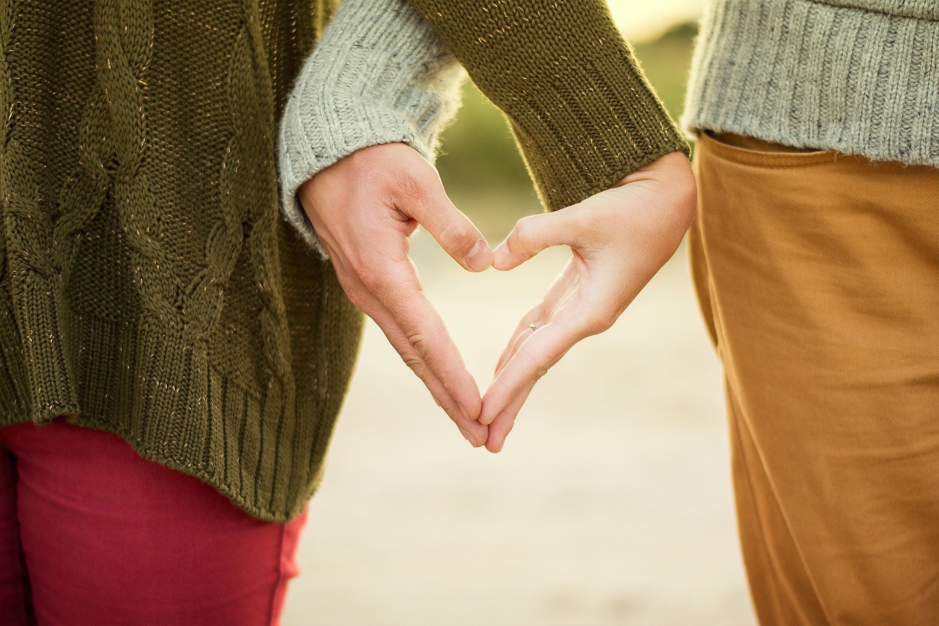 Man and woman holding hands in shape of a heart