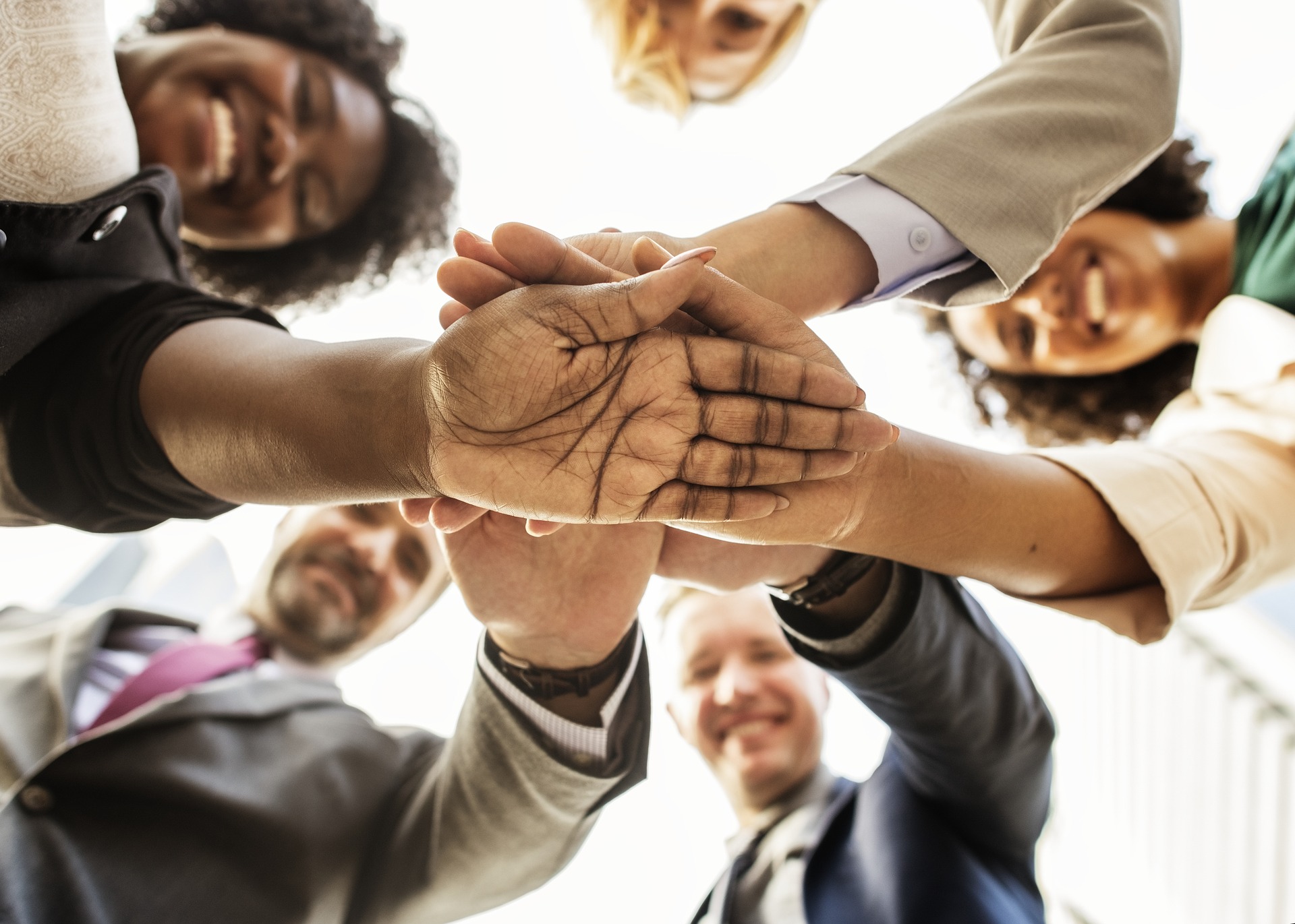 Looking up at hands of diverse employees