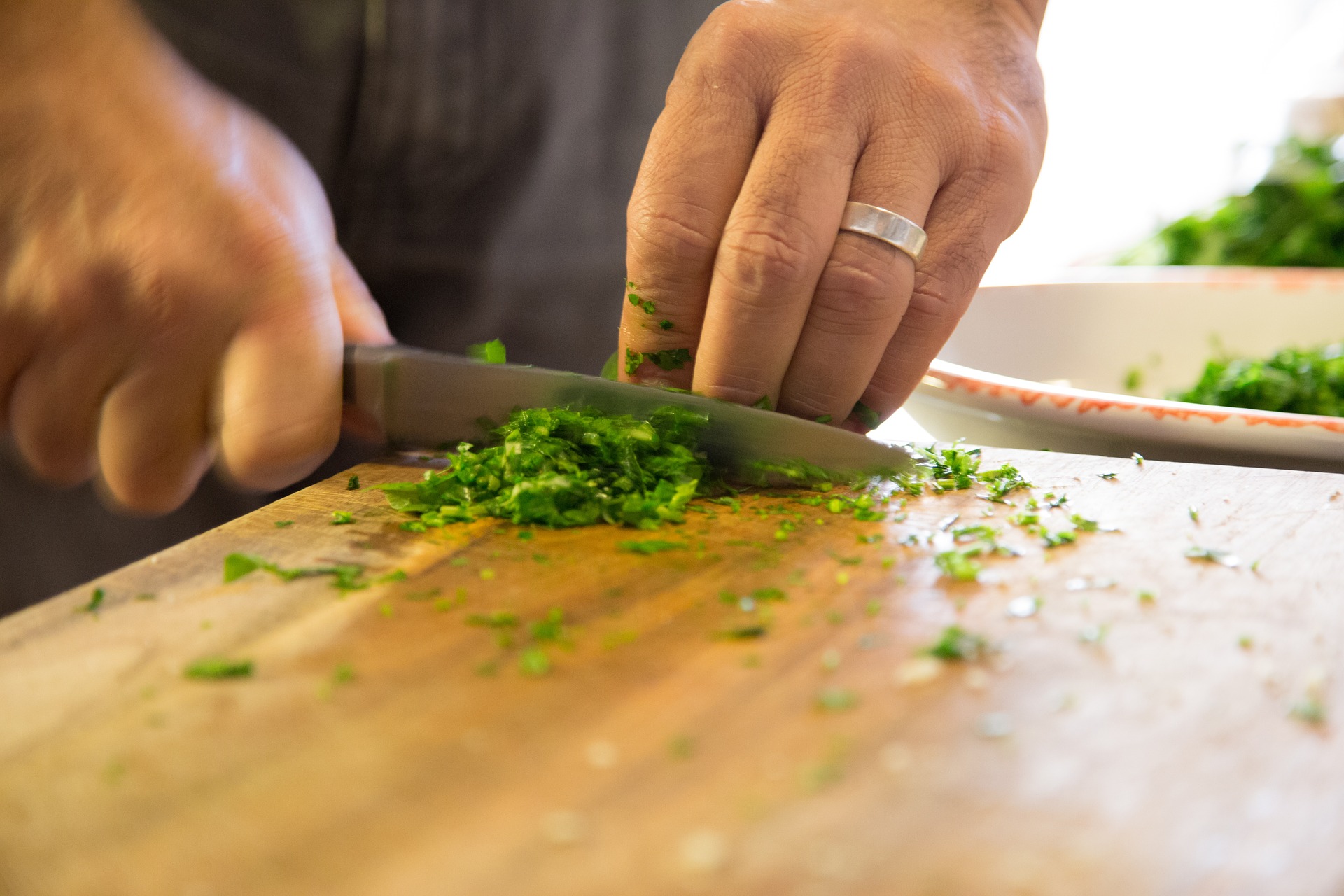 Hands cutting herbs on cutting board