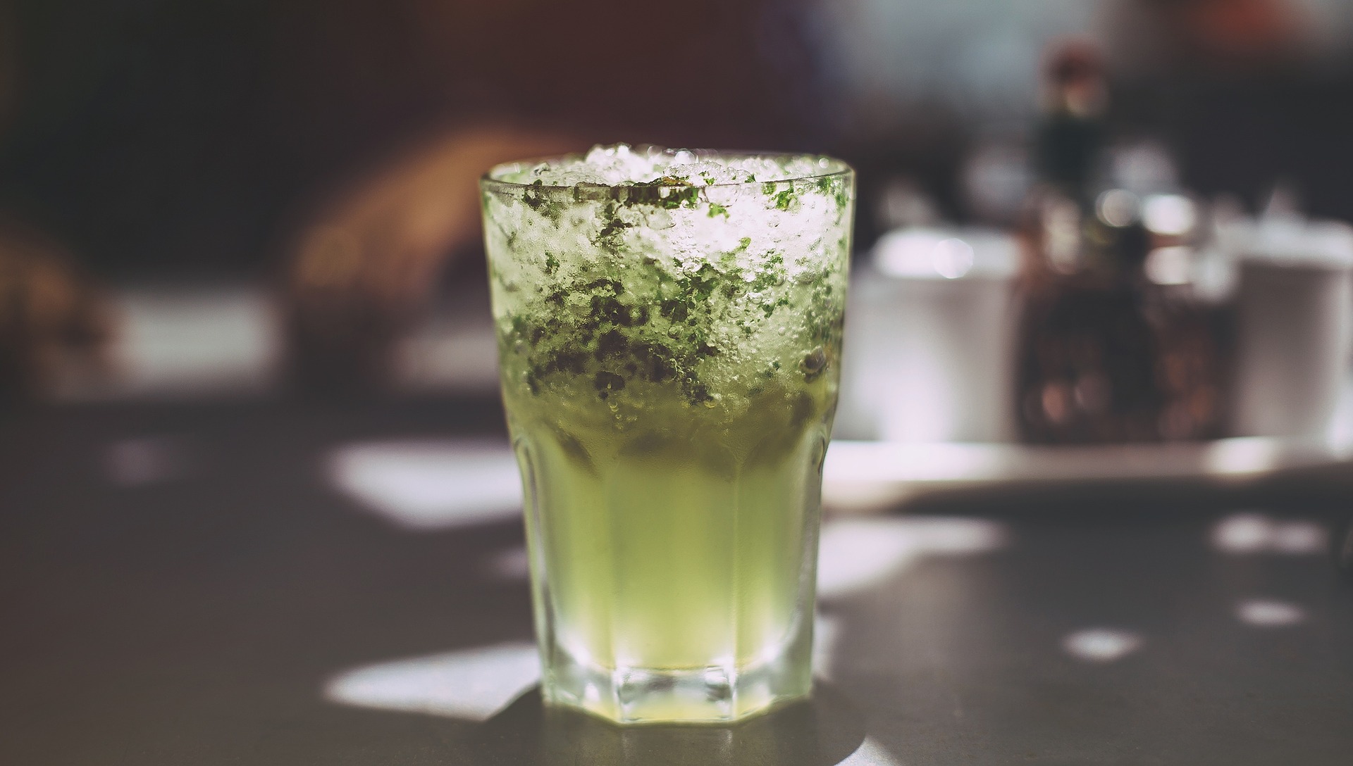 Green mixed drink sitting on bar top