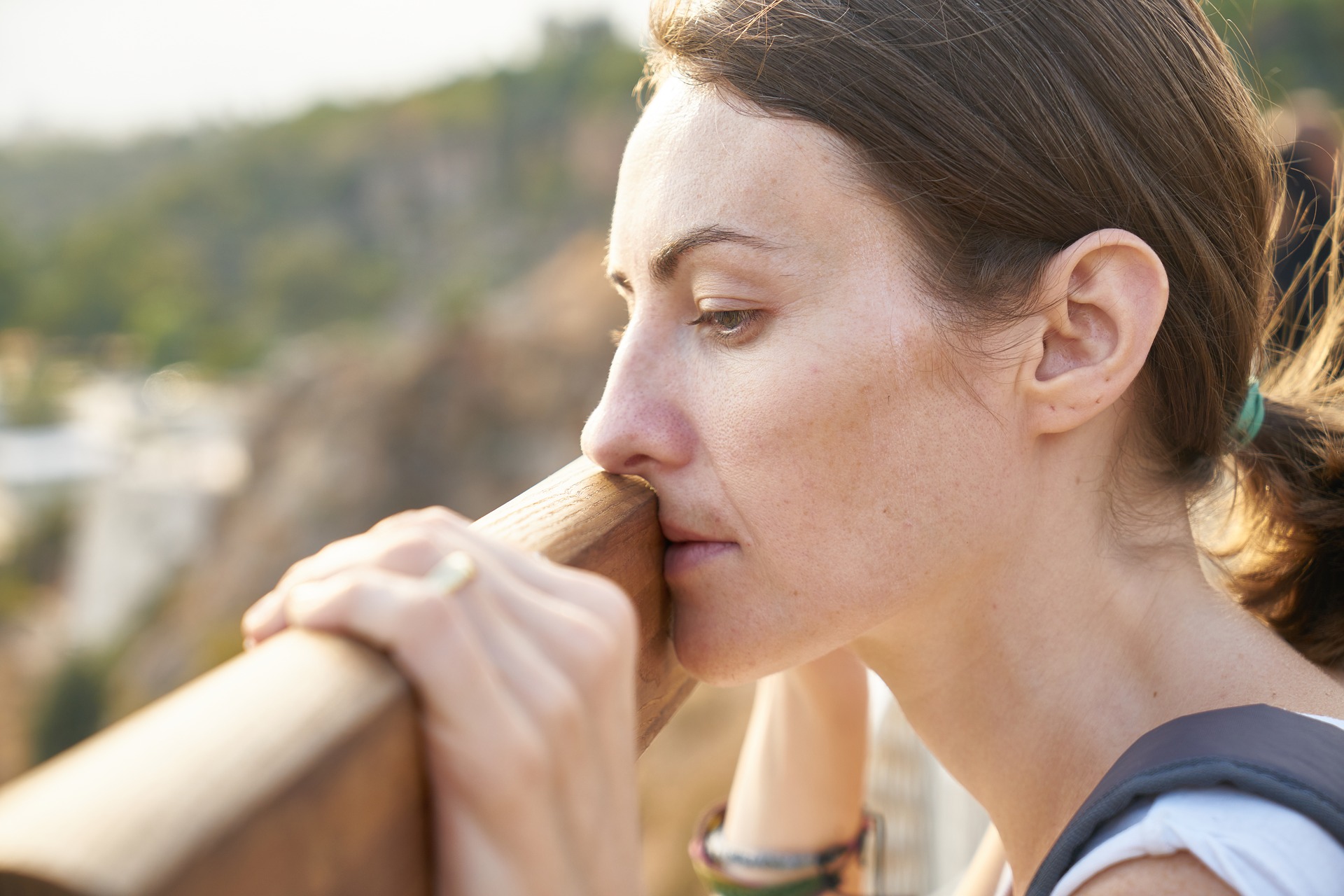 Woman's face overlooking railing as she contemplates suicide