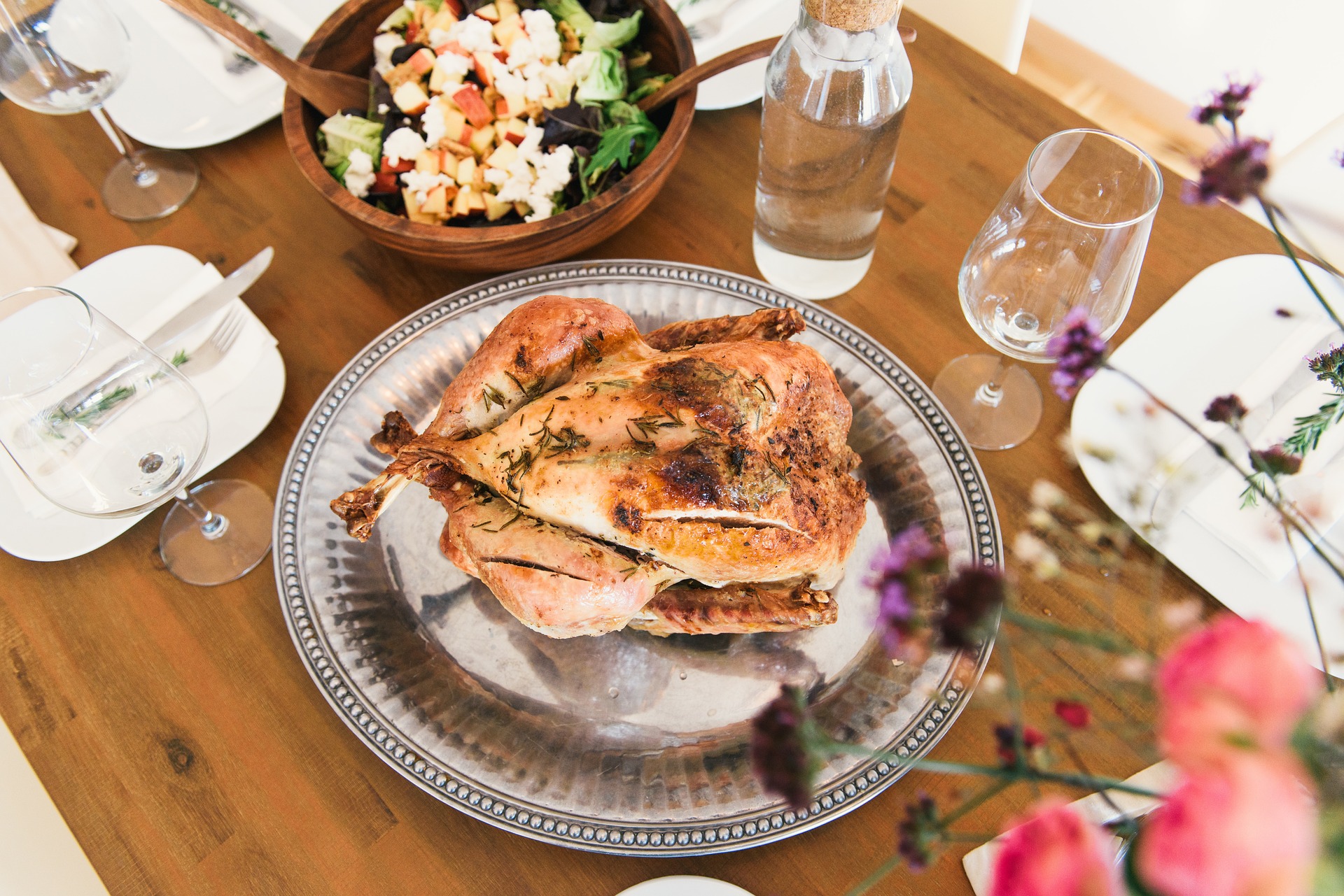 Herb-roasted turkey on a silver platter among dishes and sides