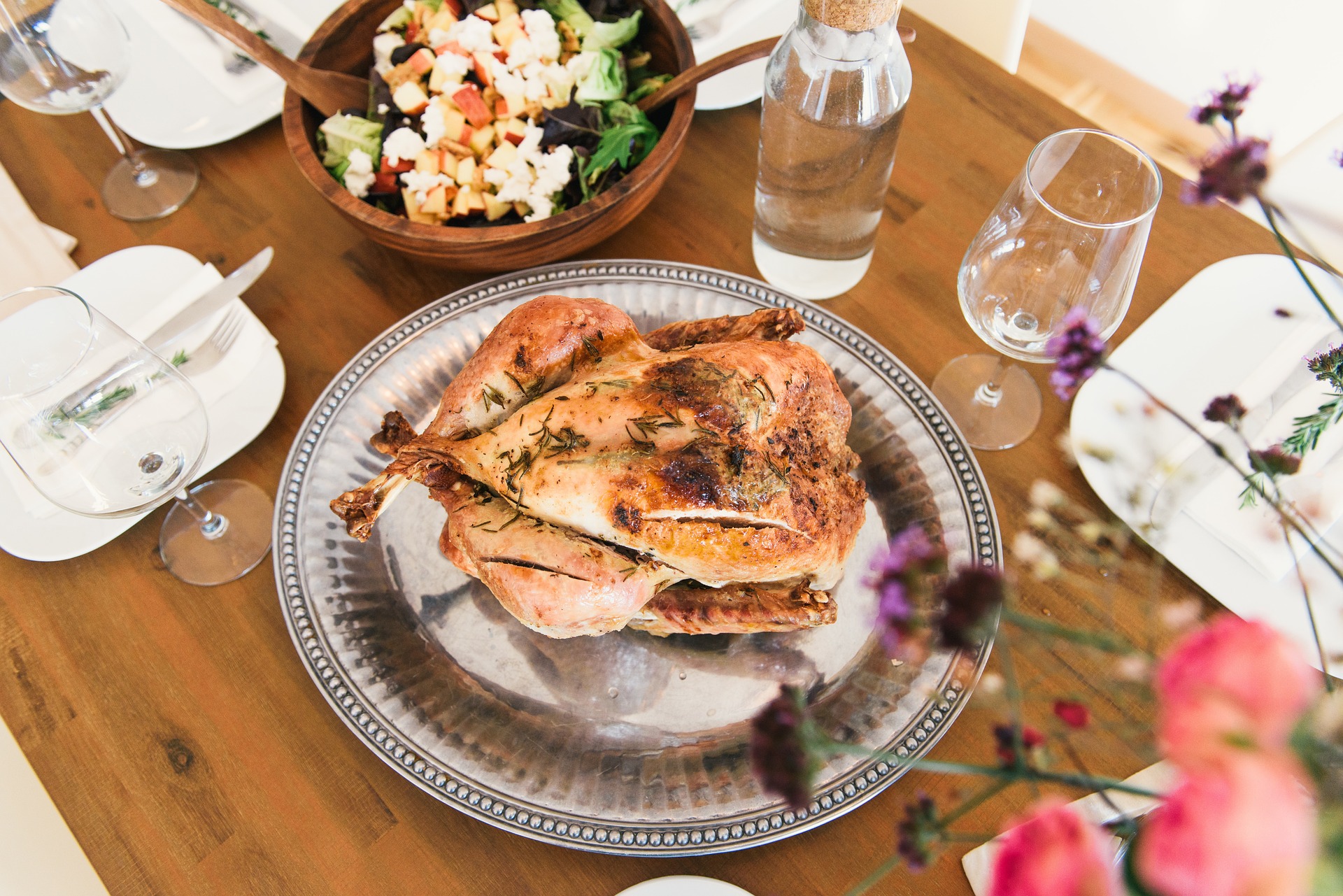 Herb-roasted turkey on a silver platter among dishes and sides