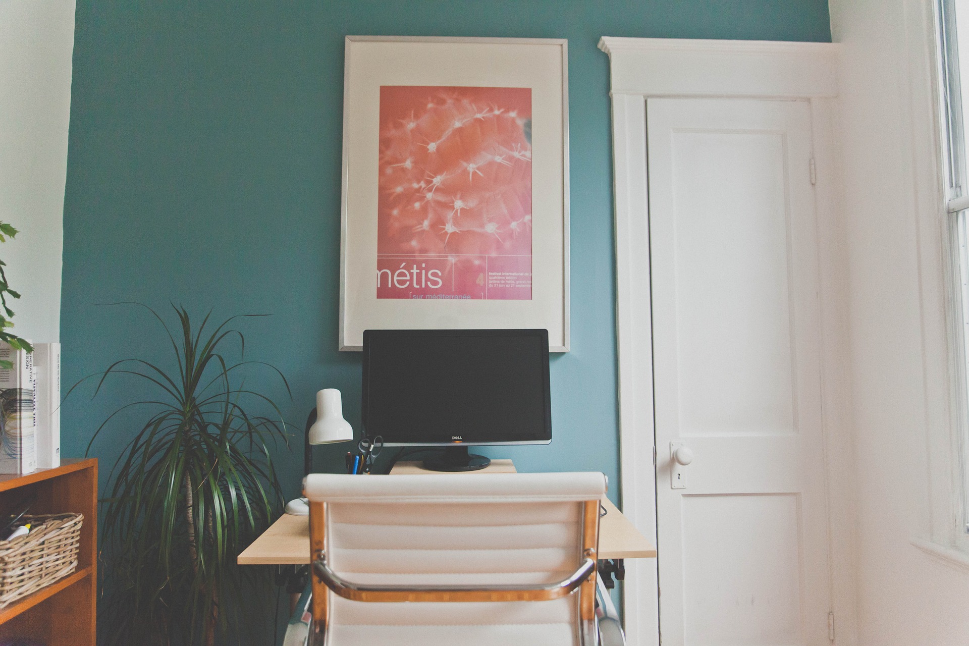 Workstation setup in a room with blue walls and a red poster