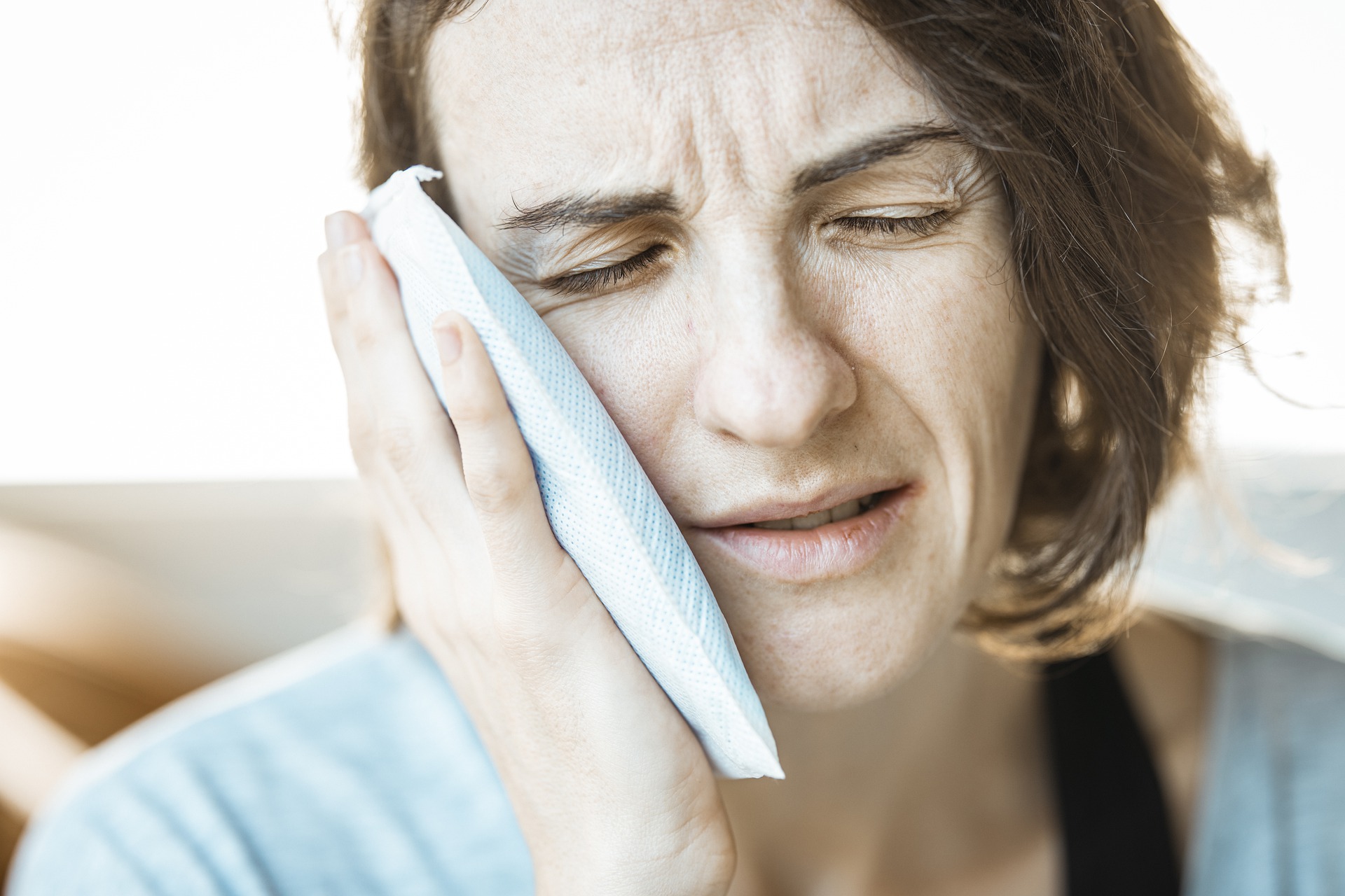 Woman holding an ice pack to her cheek