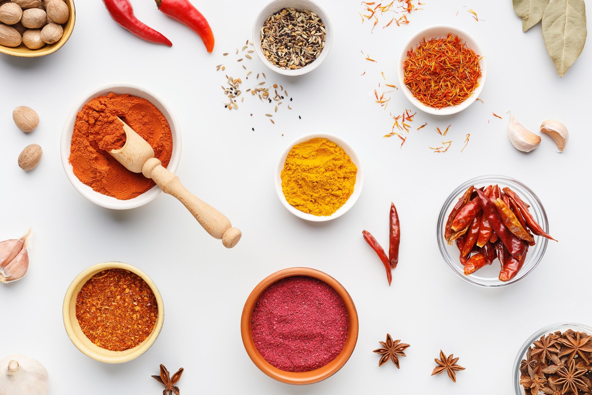 Red and orange spices in white bowls