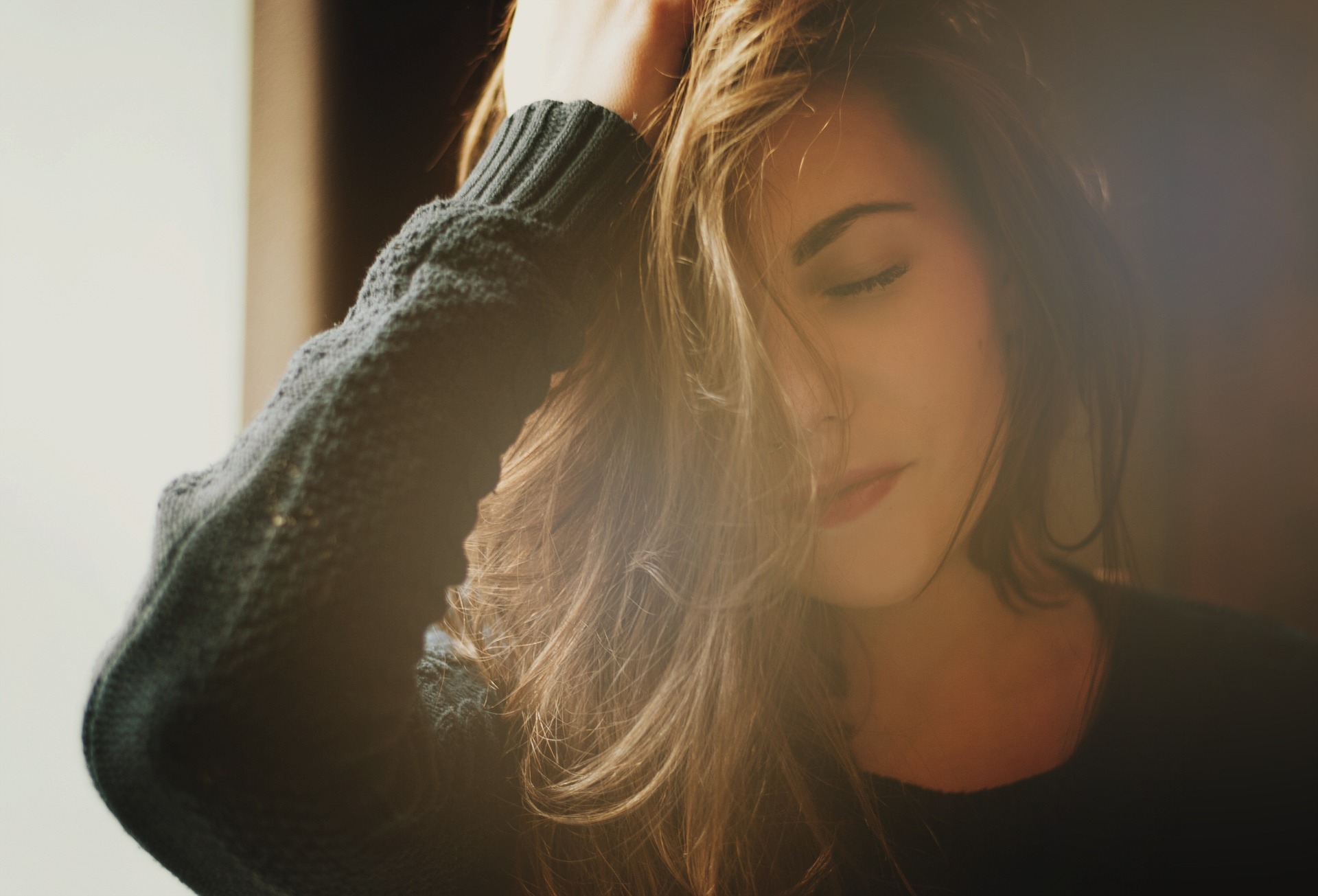 Woman in a green sweater resting head in hand